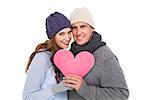 Happy couple in warm clothing holding heart on white background