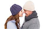 Couple in warm clothing facing each other on white background