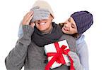 Woman surprising husband with gift on white background