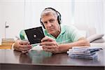 Mature man listening to cds at home in the living room