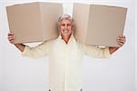 Smiling man balancing heavy cardboard boxes at home in the living room