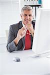 Happy businessman at his desk in his office