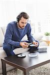 Young man listening to cds at home in the living room