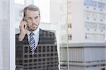 Businessman looking out window on the phone in his office