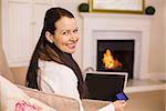 Woman doing online shopping with laptop and credit card at home in the living room