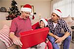 Surprised grandfather opening his gift at home in the living room