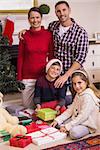 Happy family opening present at christmas at home in the living room