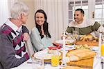 Cheerful family having christmas dinner together at home in the living room