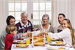 Smiling extended family at the christmas dinner table at home in the living room