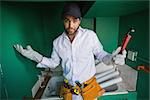 Construction worker shrugging at camera  in a new house