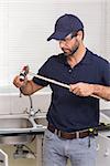 Plumber fixing pipe with wrench in the kitchen