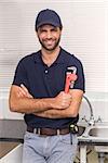 Plumber smiling at the camera in the kitchen