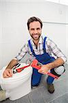 Plumber smiling at the camera in the bathroom