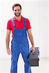 Construction worker holding tool box in a new house