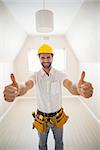 Handyman smiling at camera in tool belt in a new house