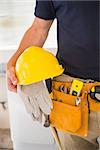 Close up of man with tool belt in a new house