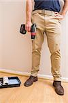 Construction worker holding power tool in a new house