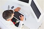 Businessman using digital tablet and computer in his office