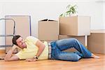 Happy man posing with moving boxes at home in the living room