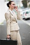 Young businesswoman talking on phone outside in the city