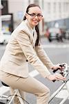 Young businesswoman riding her bike outside in the city