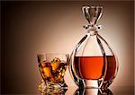 Decanter and glass of golden whiskey on brown background