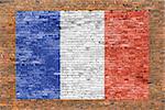 Flag of France painted over aged brick wall