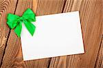 Valentines day greeting card with green bow over wooden background