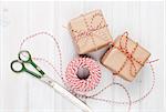 Gift wrapping with boxes and scissors over white wooden table