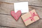 Valentines day toy heart, blank greeting card and gift box over wooden table background