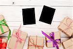 Photo frames and gift boxes with ribbons over white wooden table background