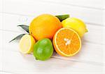 Citrus fruits. Oranges, limes and lemons. Over white wood table background