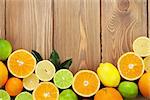 Citrus fruits. Oranges, limes and lemons. Over wood table background with copy space