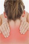 Rear view of young woman massaging neck against white background