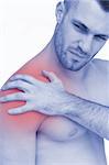 Closeup of shirtless man with shoulder pain over white background