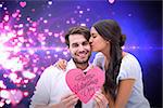 Pretty brunette giving boyfriend a kiss and her heart against valentines heart design