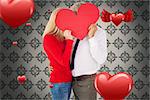 Handsome man getting a heart card form wife against grey wallpaper