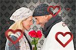 Smiling couple in winter fashion posing with roses against grey wallpaper