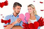 Couple holding two halves of broken heart against hearts