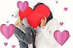 Couple in winter fashion posing with heart shape against hearts