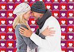 Happy couple in winter fashion embracing against valentines day pattern