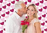 Affectionate man kissing his wife on the cheek with roses against valentines day pattern