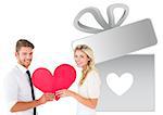 Attractive young couple holding red heart against gift with heart