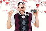 Geeky hipster holding a retro tape cassette player against valentines heart design