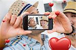 Composite image of valentines couple taking a selfie