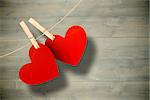 Hearts hanging on line against bleached wooden planks background