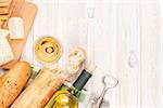 White wine, cheese and bread on white wooden table background with copy space