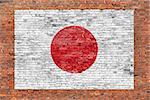 Flag of Japan painted over aged brick wall