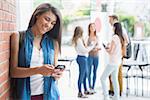 Pretty student using her smartphone at the university