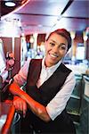 Pretty barmaid smiling at camera in a bar